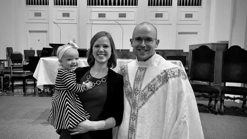 Anglikanischer Geistlicher im Messgewand mit Frau und Kind
