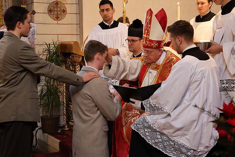 Das Phot zeigt den Augenblick, in dem der firmende Bischof einem Firmling die Hände auflegt